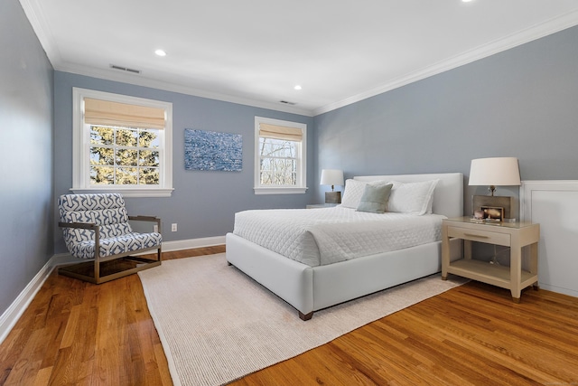 bedroom featuring recessed lighting, wood finished floors, baseboards, visible vents, and crown molding