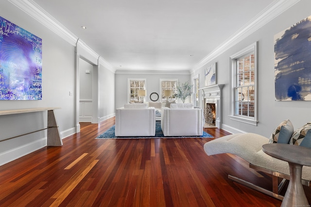 living area featuring a fireplace with flush hearth, wood finished floors, and a healthy amount of sunlight
