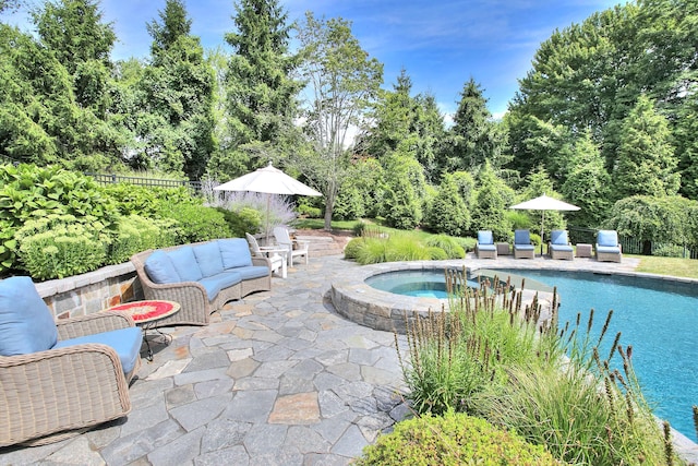 outdoor pool with fence, an in ground hot tub, and a patio area
