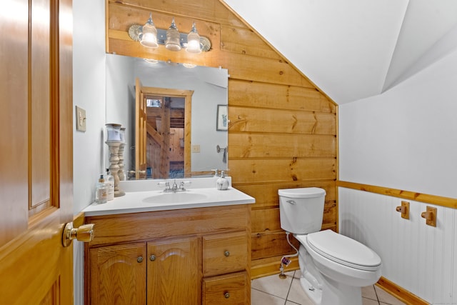 bathroom featuring tile flooring, lofted ceiling, toilet, and vanity