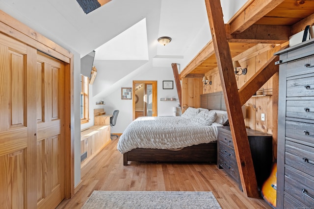 bedroom featuring beamed ceiling and light hardwood / wood-style floors