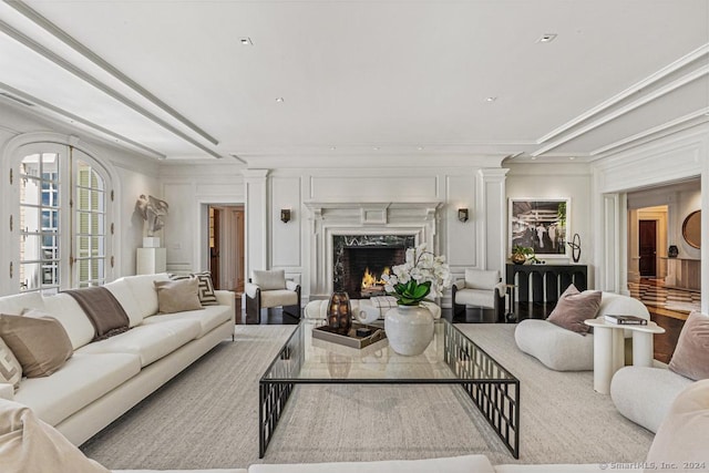 living room featuring ornamental molding, a fireplace, and french doors