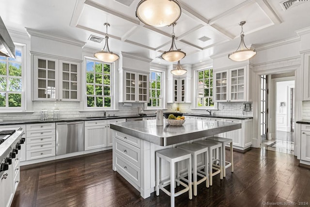 kitchen featuring pendant lighting, a center island, stainless steel dishwasher, and a wealth of natural light