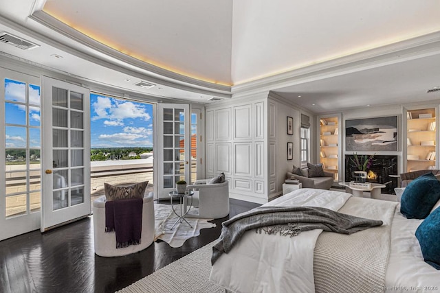 bedroom with access to outside, french doors, crown molding, a premium fireplace, and a tray ceiling