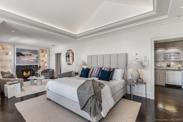 bedroom with crown molding, a fireplace, and dark wood-type flooring