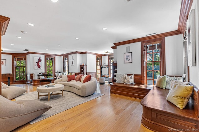 living room featuring crown molding and light hardwood / wood-style floors