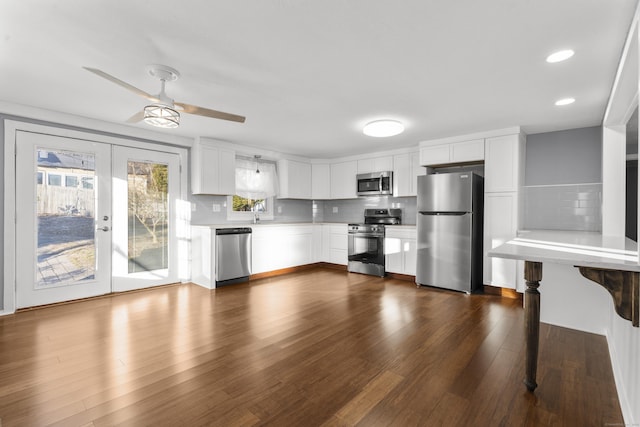 kitchen with decorative backsplash, french doors, stainless steel appliances, ceiling fan, and white cabinetry