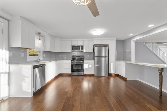 kitchen with white cabinets, pendant lighting, sink, and stainless steel appliances