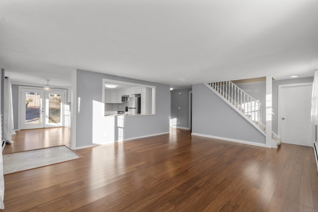 unfurnished living room with french doors, hardwood / wood-style flooring, and ceiling fan