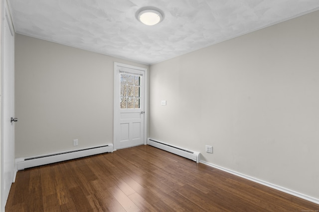 unfurnished room featuring wood-type flooring and a baseboard heating unit