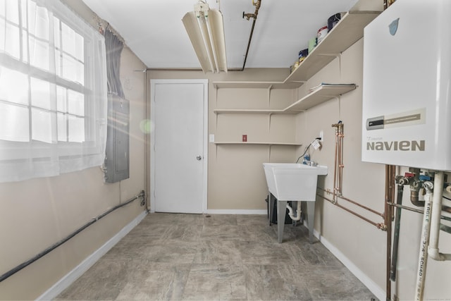 laundry area featuring electric panel, a healthy amount of sunlight, and water heater