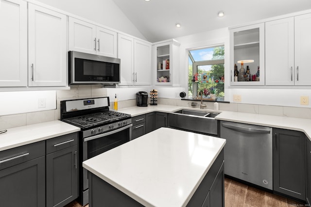 kitchen featuring sink, stainless steel appliances, dark hardwood / wood-style floors, lofted ceiling, and white cabinets