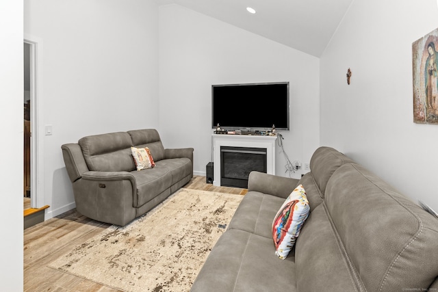 living room with light hardwood / wood-style flooring and vaulted ceiling