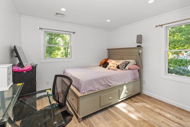 bedroom with multiple windows, crown molding, and light wood-type flooring