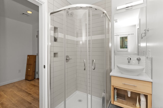 bathroom featuring vanity, wood-type flooring, and an enclosed shower