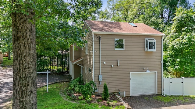 262 Great Plain Rd Unit 13, Danbury, CT 06810 - view of home's exterior featuring an attached garage, driveway, roof with shingles, and a gate