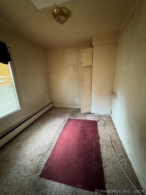 carpeted spare room with a baseboard radiator