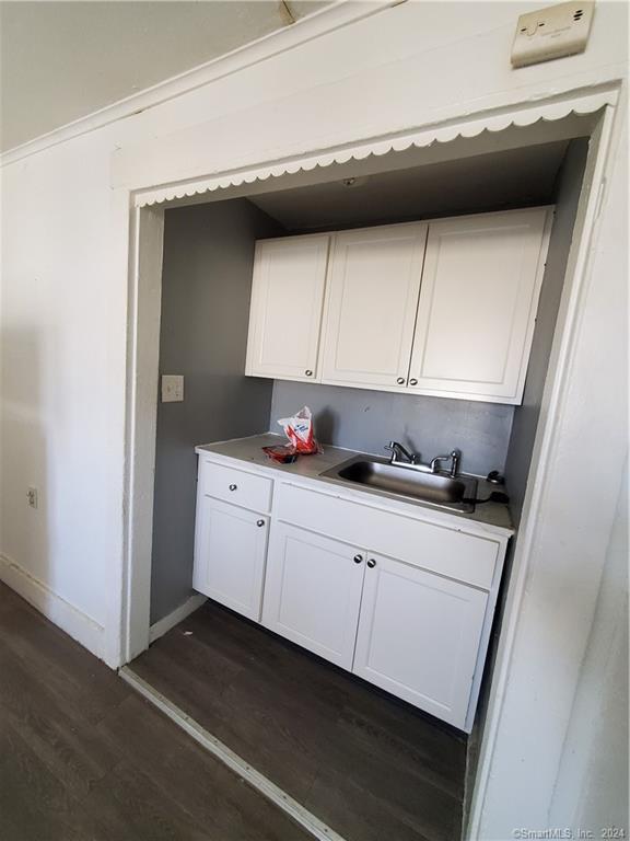 kitchen featuring white cabinetry, dark hardwood / wood-style flooring, and sink