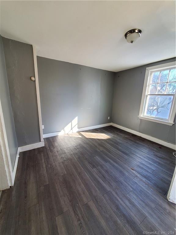 spare room featuring dark wood-type flooring