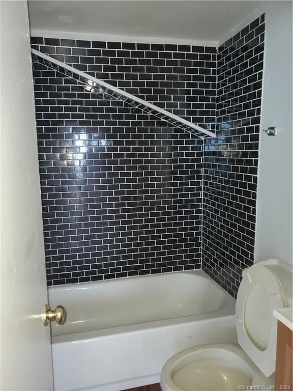 full bathroom with toilet, vanity, and tiled shower / bath