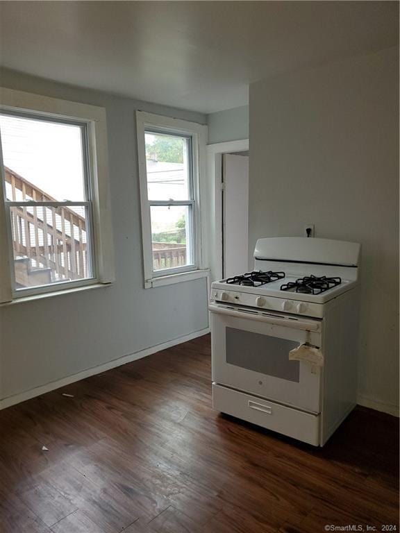 kitchen featuring white range with gas cooktop and dark hardwood / wood-style flooring