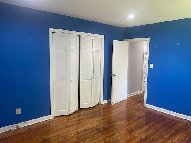 unfurnished bedroom featuring dark wood-type flooring and a closet