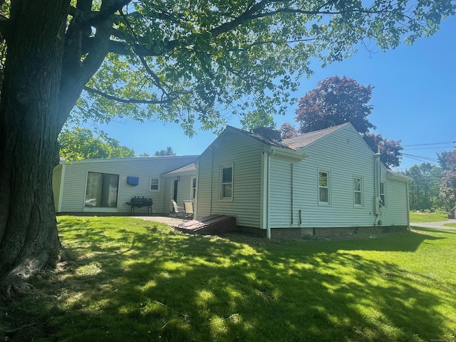 rear view of house with a patio and a lawn