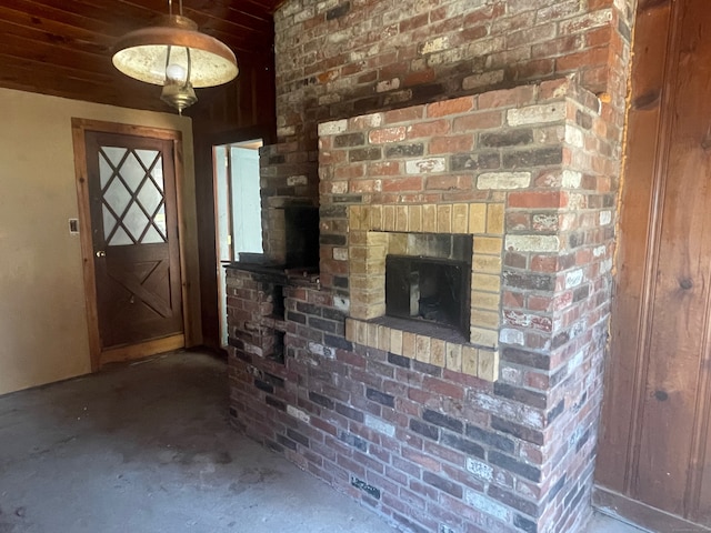 interior space with a brick fireplace and brick wall