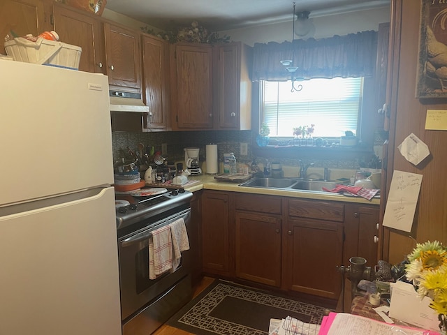 kitchen with sink, tasteful backsplash, white fridge, pendant lighting, and stainless steel electric stove