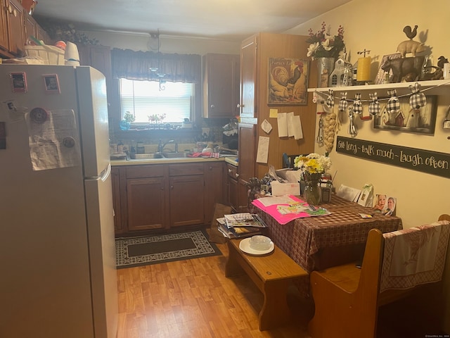 kitchen featuring white refrigerator, sink, and light hardwood / wood-style floors