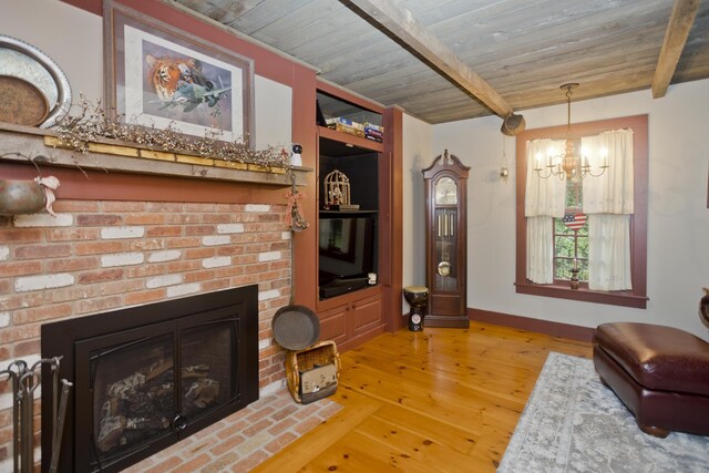 living room with beam ceiling, an inviting chandelier, a brick fireplace, wood ceiling, and light wood-type flooring