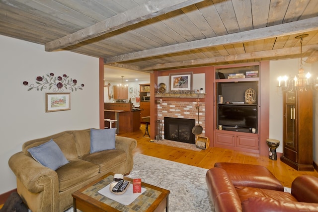 living room with hardwood / wood-style floors, a fireplace, beamed ceiling, wood ceiling, and a chandelier