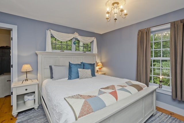 bedroom featuring a chandelier and hardwood / wood-style flooring