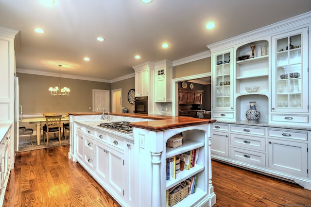 kitchen with oven, butcher block counters, hardwood / wood-style floors, white cabinetry, and pendant lighting