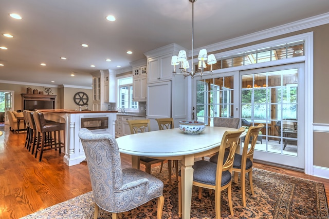 dining room featuring crown molding, hardwood / wood-style flooring, and a chandelier