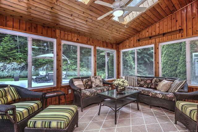 sunroom / solarium with ceiling fan, a wealth of natural light, wood ceiling, and lofted ceiling with skylight