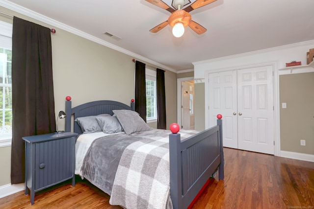 bedroom with crown molding, hardwood / wood-style flooring, multiple windows, and ceiling fan