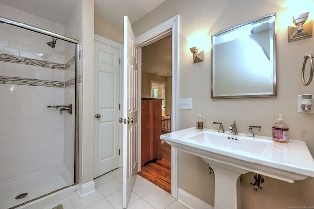 bathroom with tile patterned floors, sink, and a tile shower