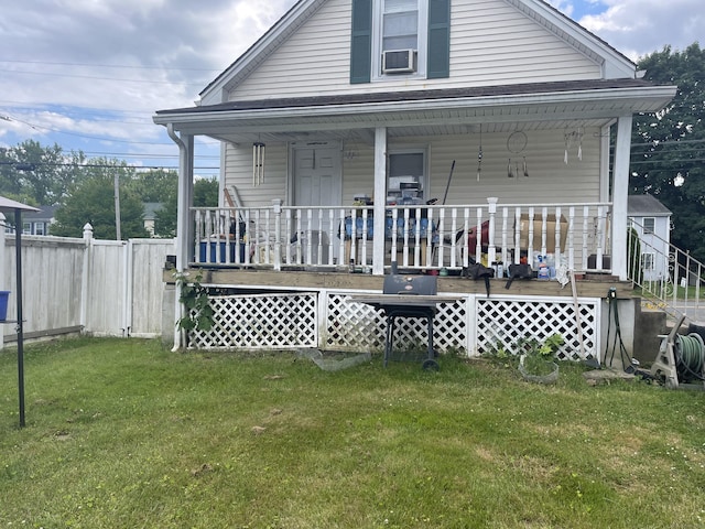 back of property with a yard and a porch