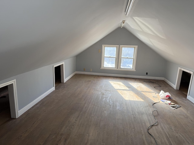 bonus room with dark hardwood / wood-style flooring and lofted ceiling