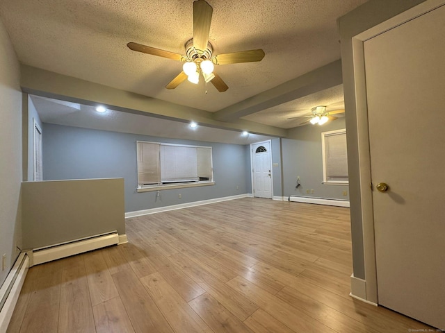 spare room with a textured ceiling, light hardwood / wood-style floors, and baseboard heating