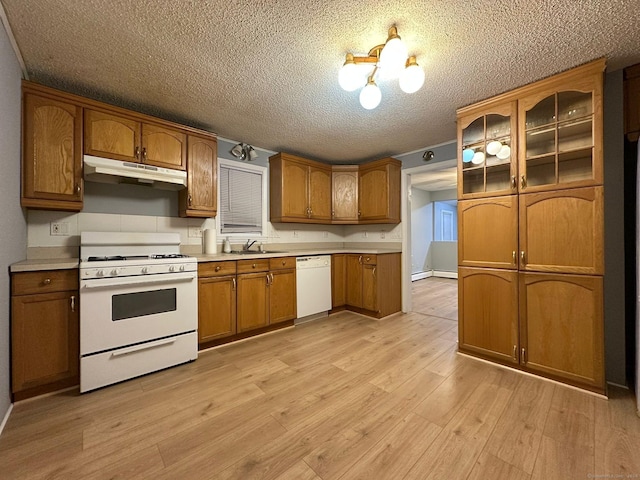 kitchen with white appliances, sink, light wood-type flooring, a textured ceiling, and baseboard heating