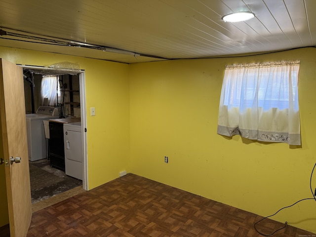 empty room with dark parquet flooring and independent washer and dryer