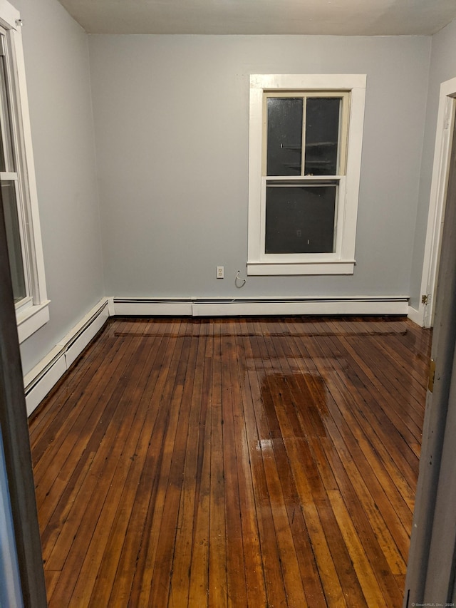 spare room with dark hardwood / wood-style floors and baseboard heating