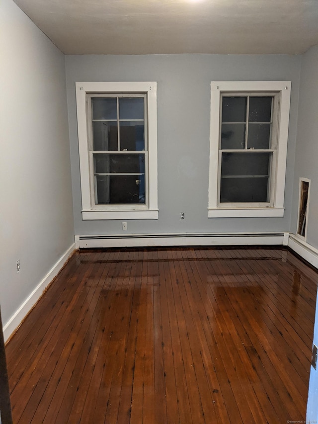 spare room with dark hardwood / wood-style flooring and a baseboard radiator