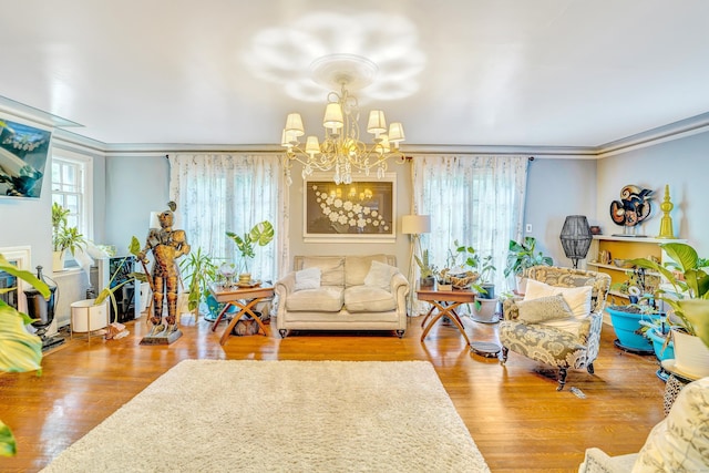 living room featuring a notable chandelier, light hardwood / wood-style floors, and crown molding