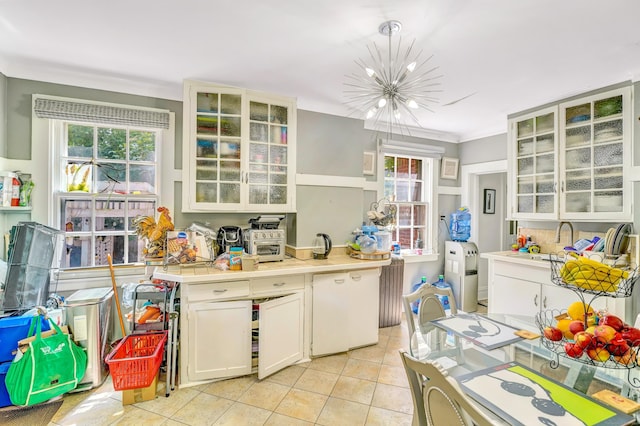 kitchen featuring white cabinetry, sink, hanging light fixtures, a chandelier, and light tile patterned floors