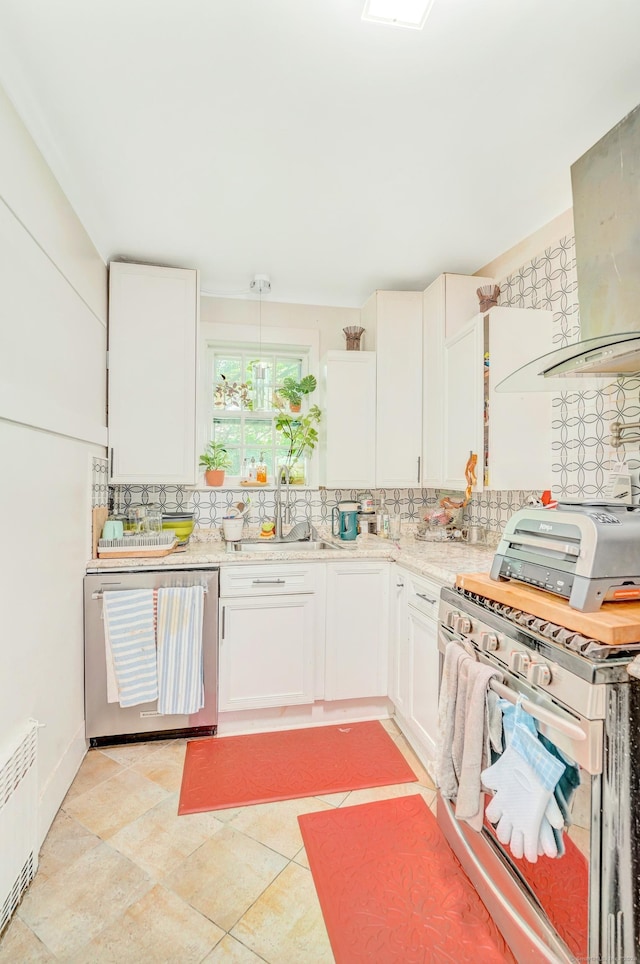 kitchen with decorative backsplash, stainless steel appliances, decorative light fixtures, white cabinets, and radiator heating unit