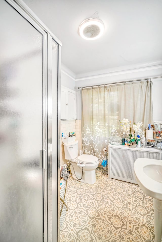 bathroom with tasteful backsplash, an enclosed shower, and toilet