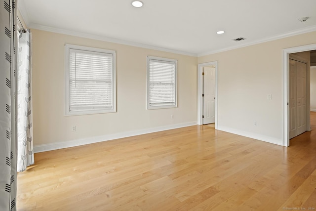 unfurnished room featuring ornamental molding and light hardwood / wood-style flooring